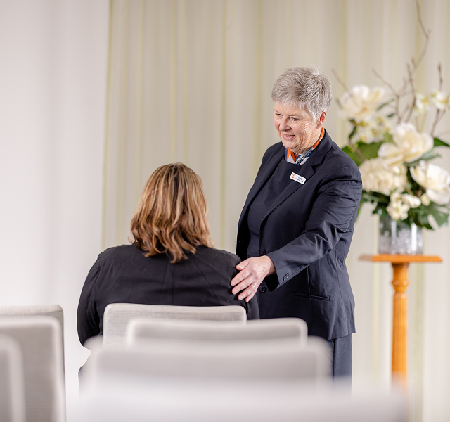 funeral director supporting woman